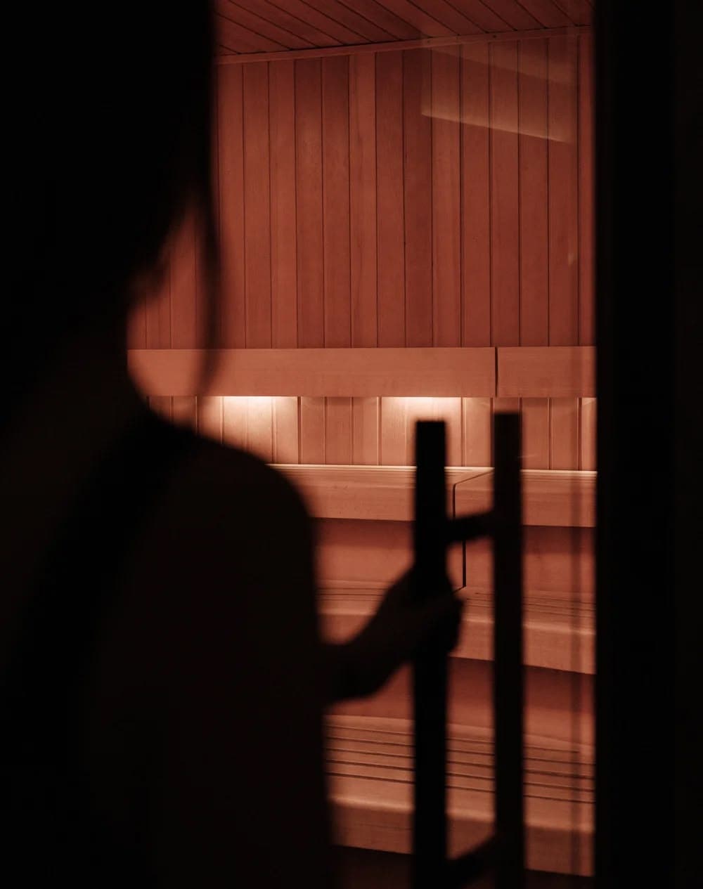 Open doorway into the lit infrared sauna cabin